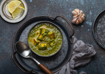 spinach and paneer curry on a dark background