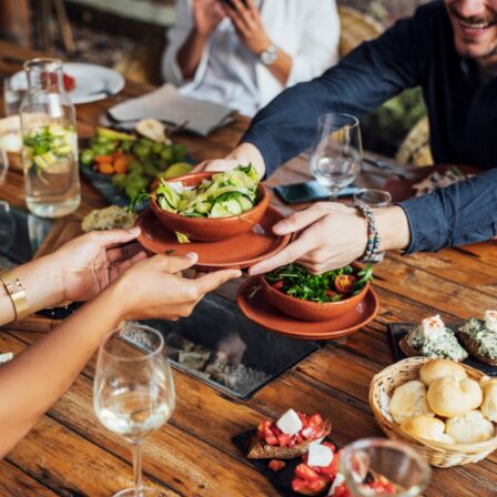 People at restaurant table being served food